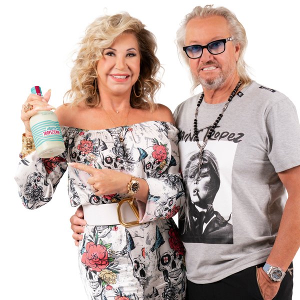 Robert und Carmen Geiss stehen vor weißem Hintergrund, halten Flasche Liqueur Tropézienne in der Hand