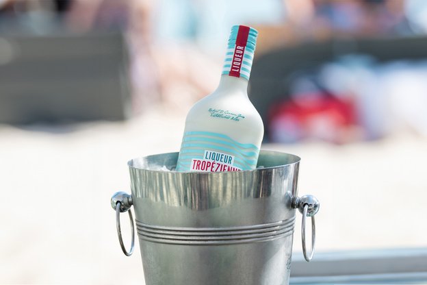 Flasche Liqueur Tropézienne steht in Eiskühler auf Tisch in Beachclub am Plage Pampelonne